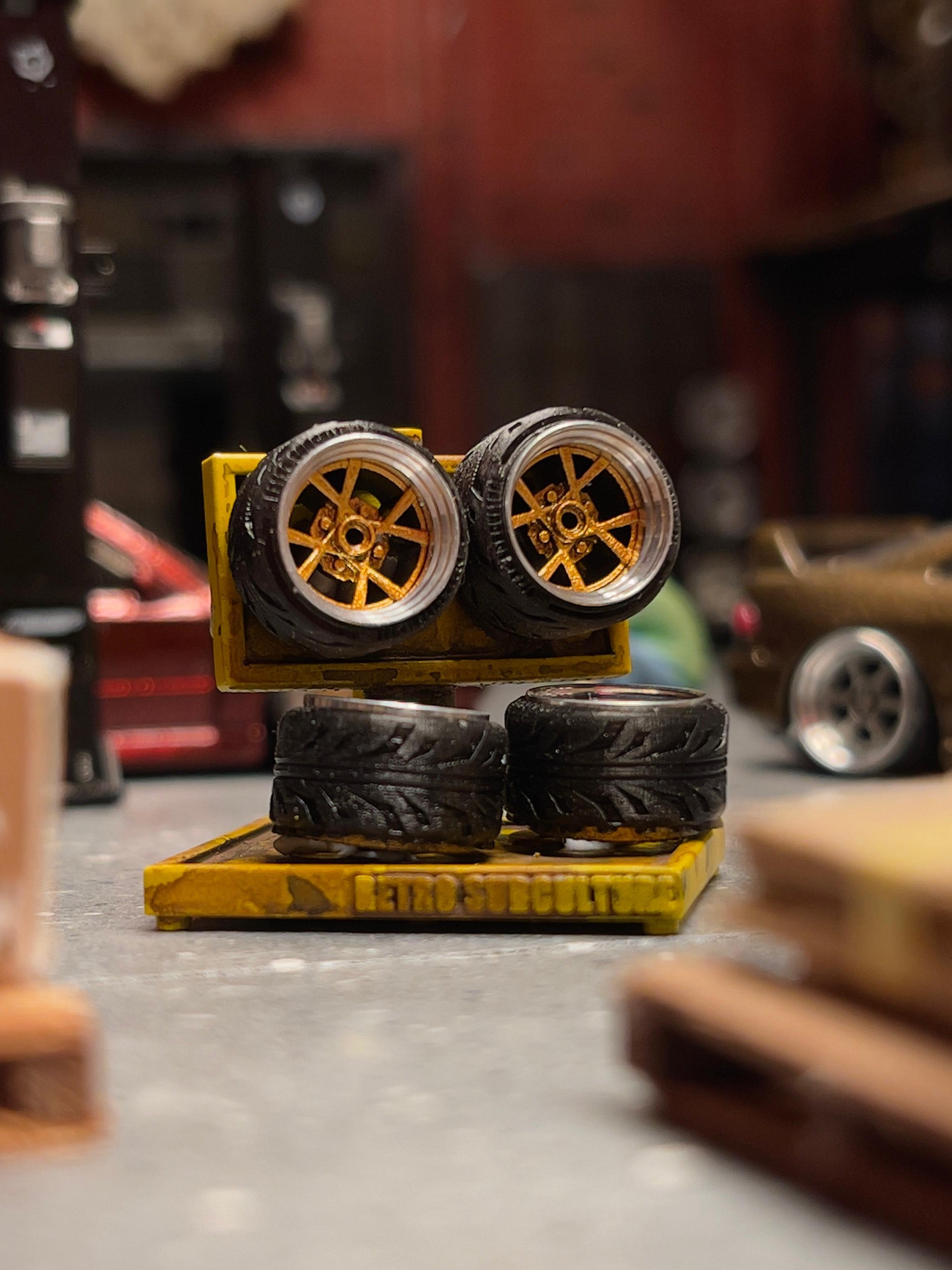 Set of model car tires on a stand in a workshop setting